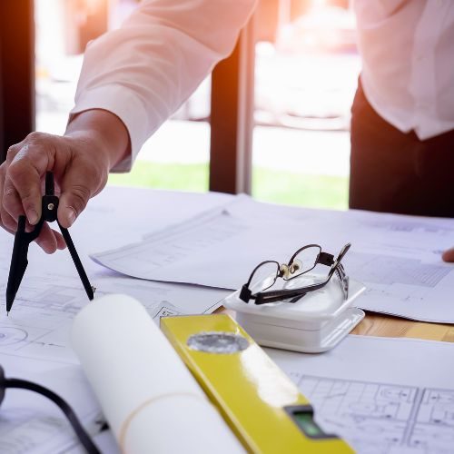 man-working-on-blue-print-on-desk-for-new-construction